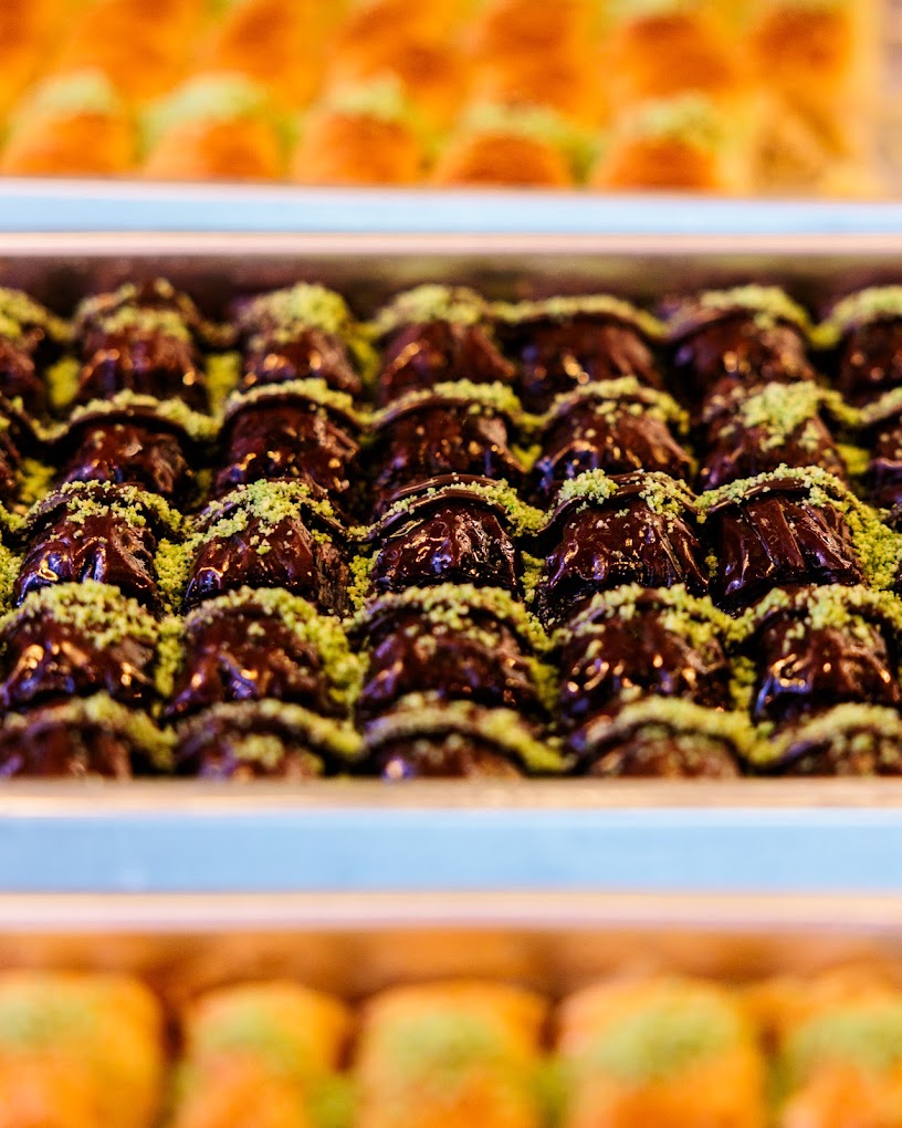 Rows of handmade chocolate and pistachio pastries in the Cafe Amara display